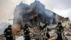 Emergency workers at a site where private houses were destroyed in a Russian strike in the Kyiv region on Sunday