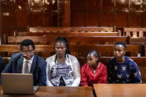Mbiyu Kamau, representing the family, follows a 2023 court hearing remotely with Rose Wanyua, Stacy Wanjiru and Esther NjokiLUIS TATO/AFP/GETTY IMAGES