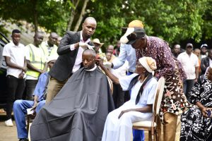 A grandmother performs the symbolic shaving ritual on Raila Junior, marking renewal and the assumption of responsibility.
