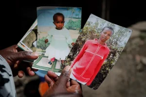 Rose Wanyua Wanjiku, elder sister to Agnes Wanjiru, 20, holds photographs of Agnes at Rose’s house in the Majengo informal settlement in Nanyuki, Kenya, November 4, 2021 [File: Brian Inganga/AP]